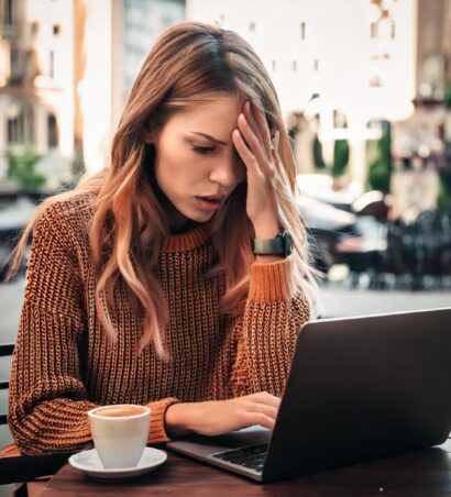 Frau beim SEO-Relaunch verzweifelt. Sitzt im Café