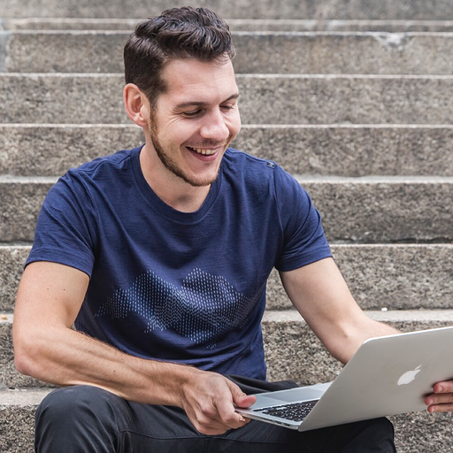Mann arbeitet im Freien an einem Laptop